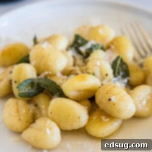 Brown butter gnocchi with sage on a white plate, ready to be served.