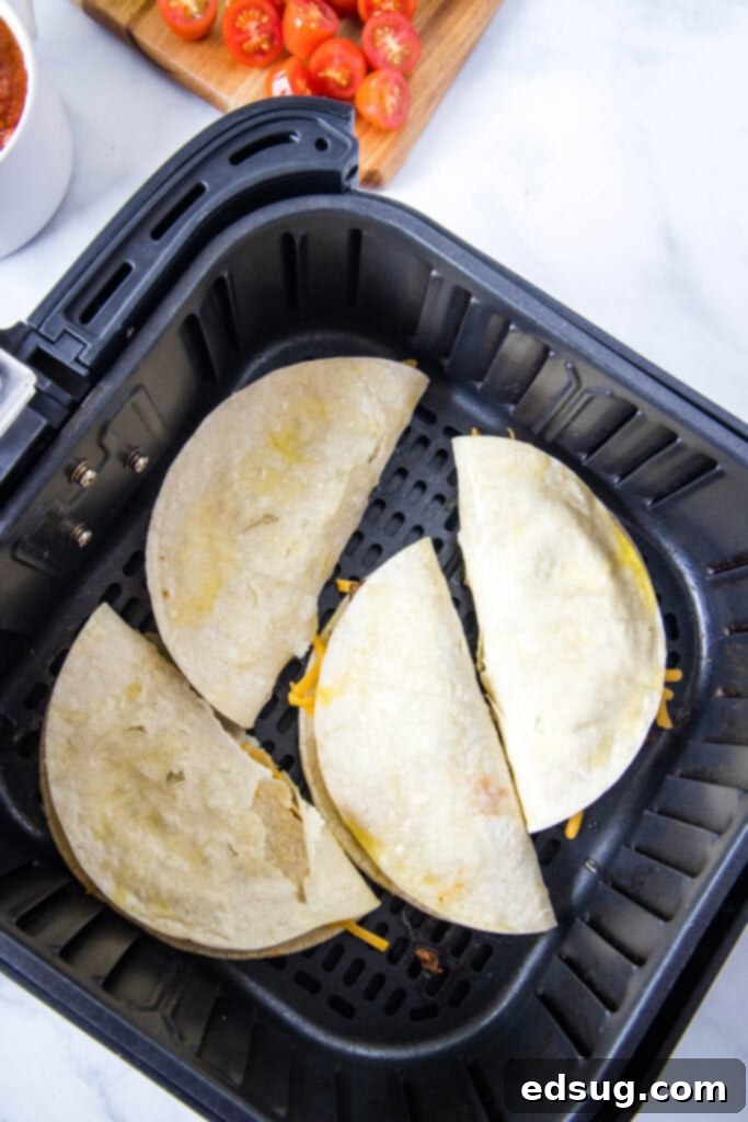 Crispy Air Fryer Tacos 4 Several filled and folded tacos cooking inside an air fryer basket, achieving a perfect golden-brown crispness.