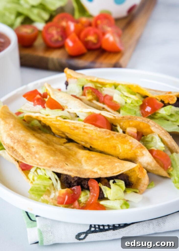 Crispy Air Fryer Tacos 6 A side view of a stack of perfectly air-fried crispy tacos on a white plate, showcasing their inviting texture and delicious fillings.