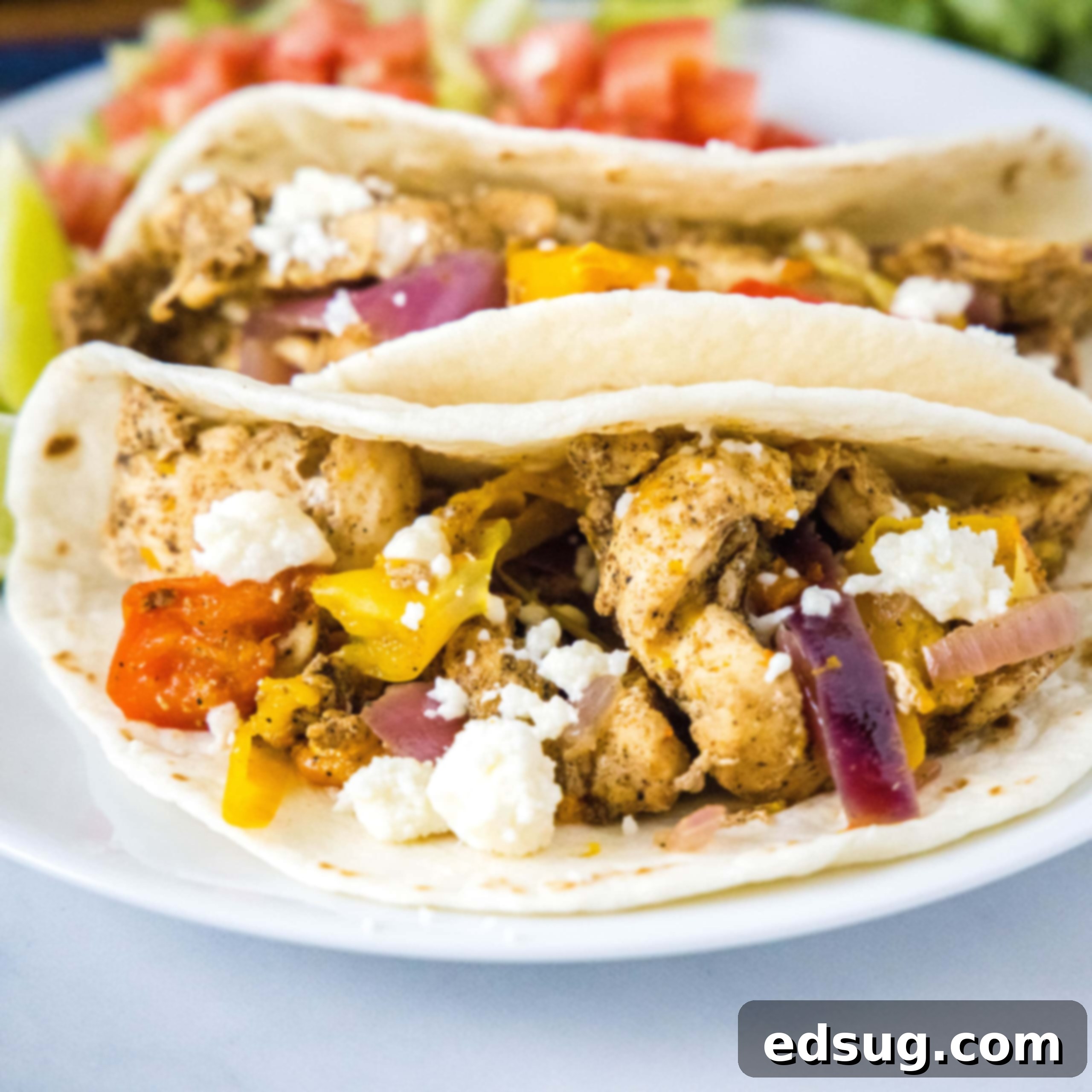 close up square image of chicken fajitas on a white plate