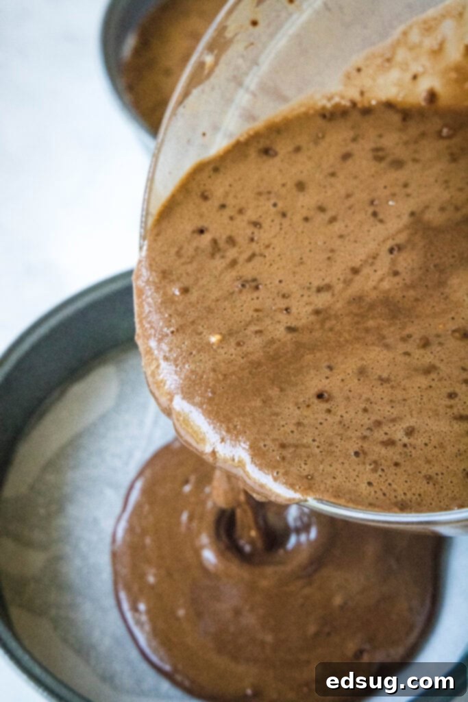 pouring cake batter into pans
