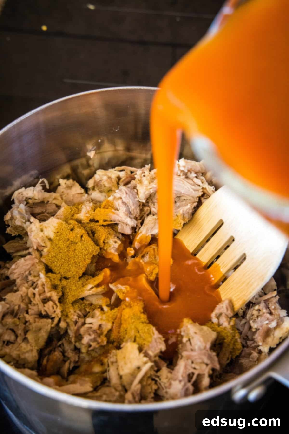 Savory Pork Enchiladas 4 pouring enchilada sauce over pulled pork