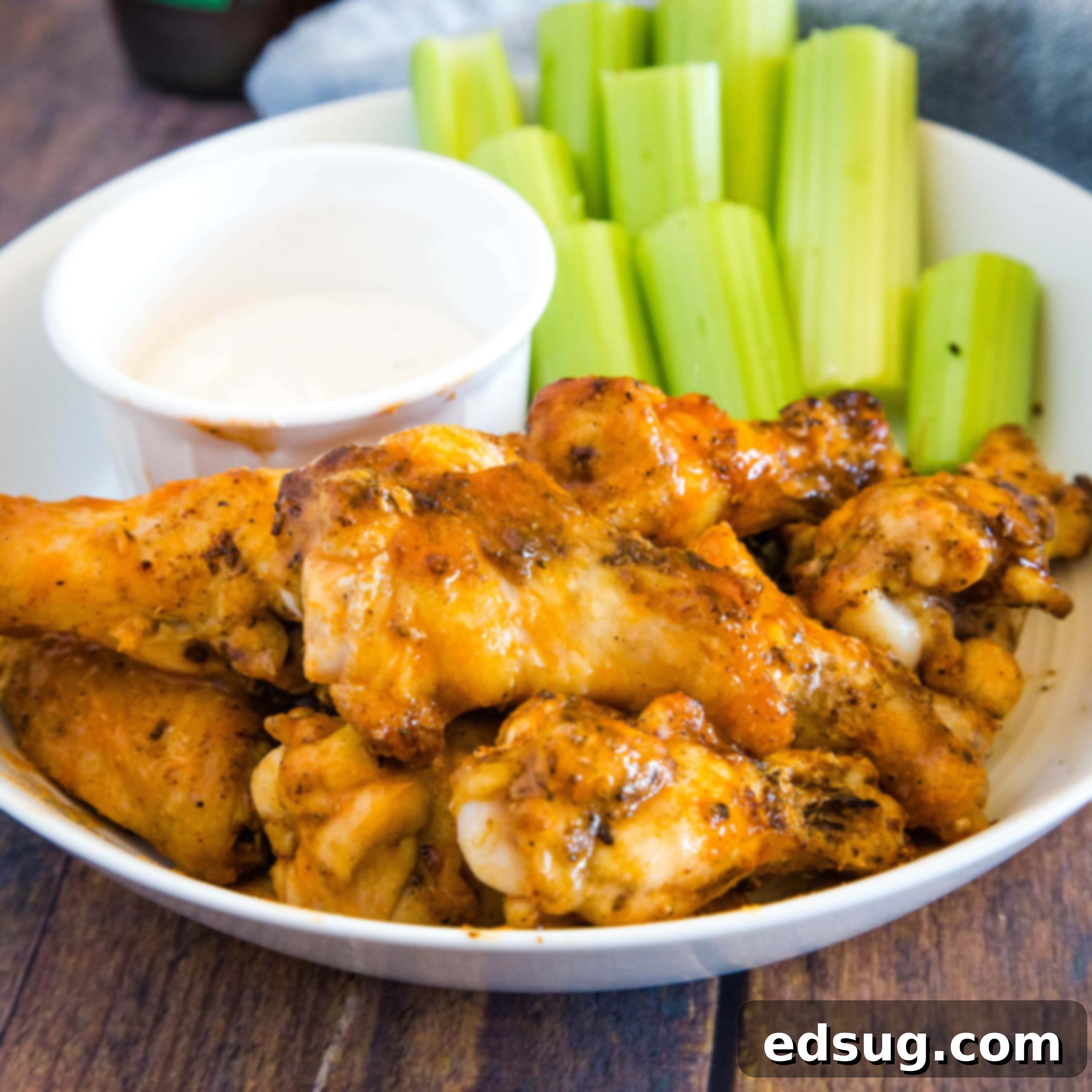 cropped image of buffalo chicken wings on plate with ranch and celery sticks