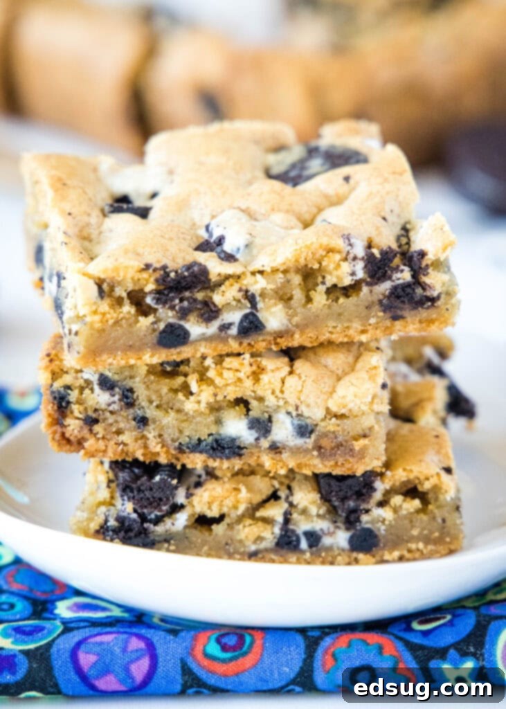 stacked cookies and cream bars on a white plate