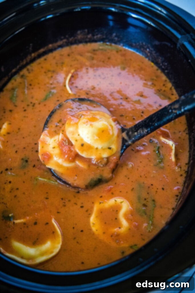 a ladle in the crockpot with tortellini soup