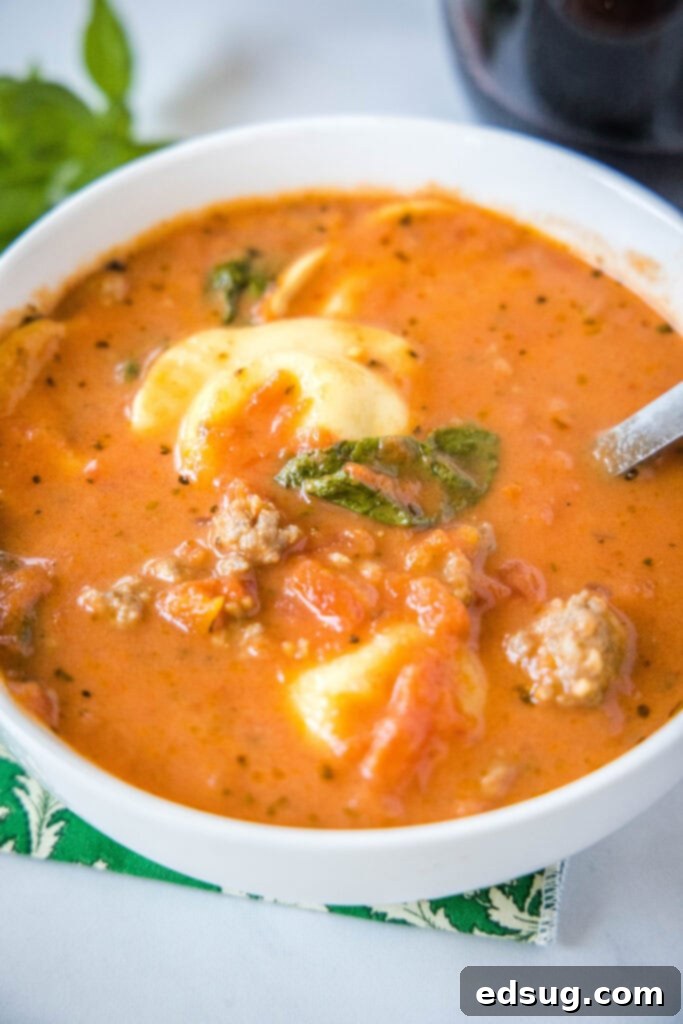 a bowl with a spoon in it of sausage tortellini soup