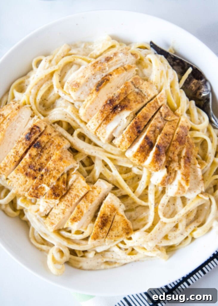 a large bowl of cajun alfredo with chicken on top