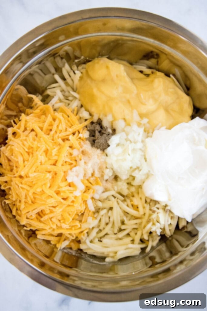 Easy Crockpot Cheesy Hashbrown Bake 3 A large bowl filled with all the Crockpot Hashbrown Casserole ingredients mixed together, ready for the slow cooker.
