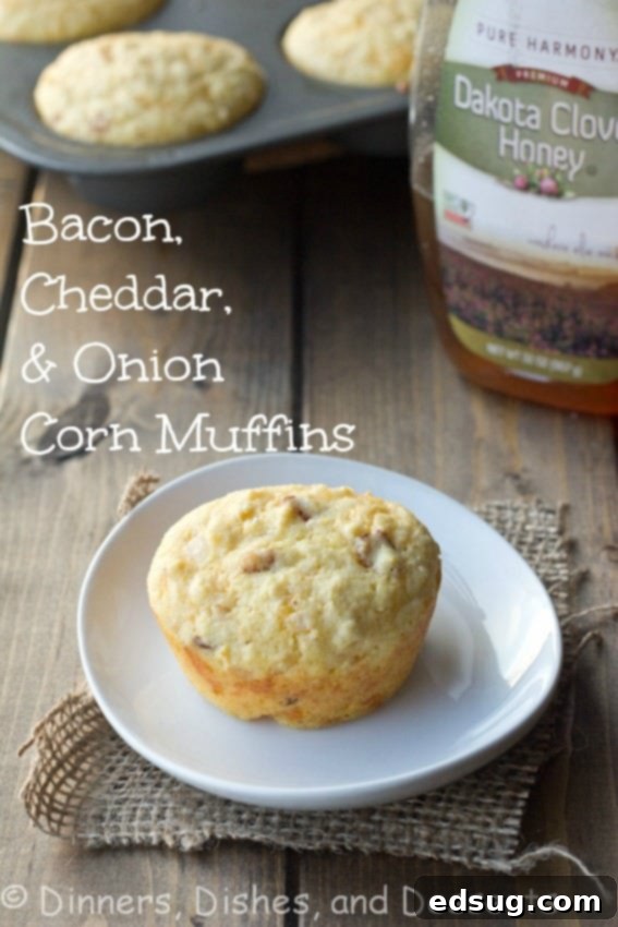 Golden-brown bacon, cheddar, and onion corn muffins cooling on a wire rack, with some sliced open to reveal their fluffy, savory interior.