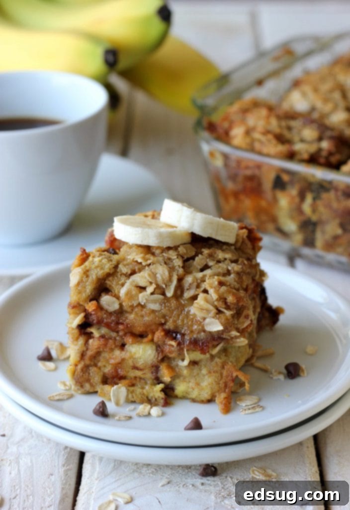 Golden-brown banana and chocolate chip baked french toast, garnished with powdered sugar and fresh berries, ready for breakfast or brunch.