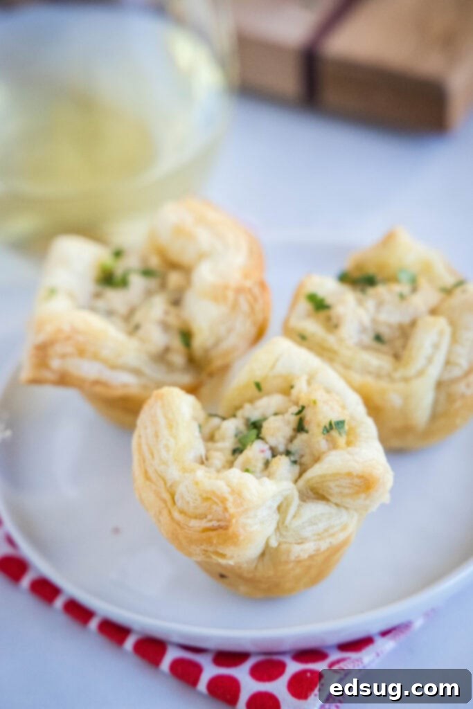 crab puffs on a white plate, garnished with fresh parsley for an elegant appetizer presentation