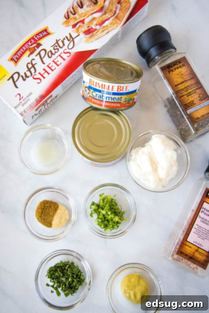 crab puff ingredients including puff pastry, crab meat, mayo, and seasonings, neatly arranged on a white surface