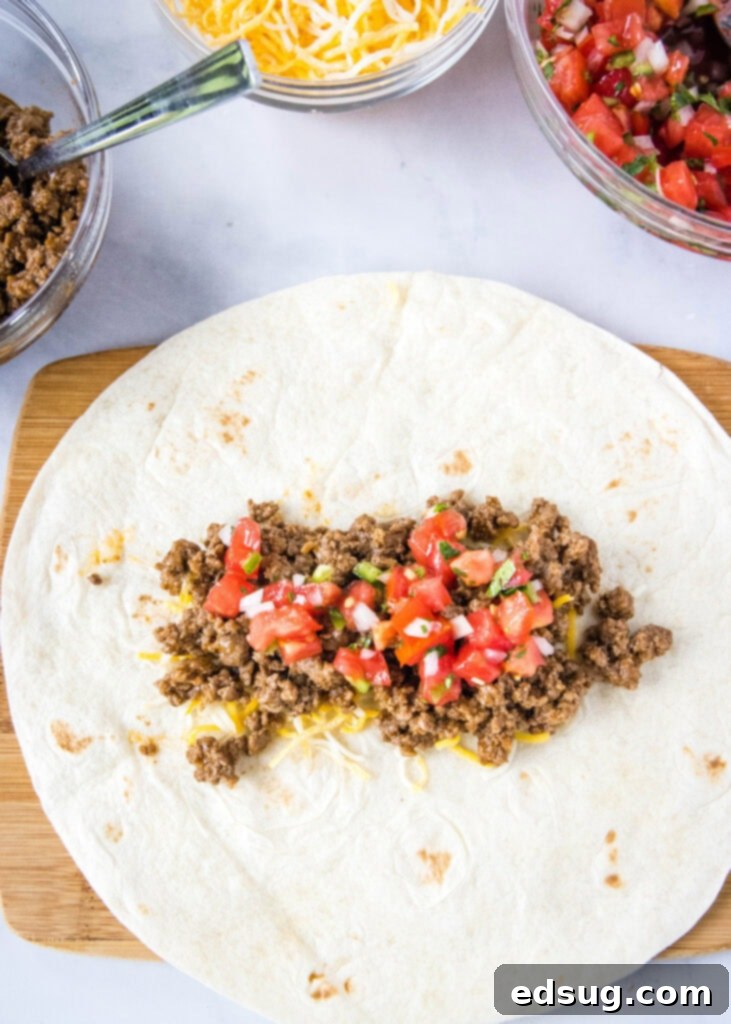 Taco Bell Copycat Meximelt Recipe 3 putting pico de gallo over ground beef in a tortilla