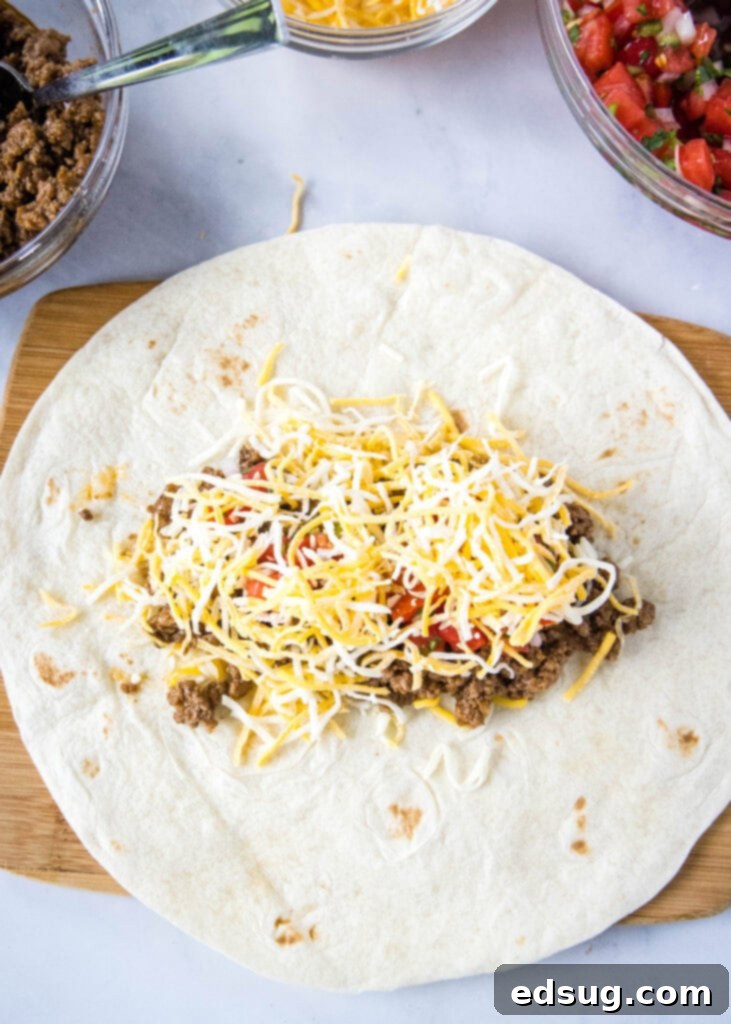 Taco Bell Copycat Meximelt Recipe 4 adding cheese to tortilla over tomatoes and ground beef