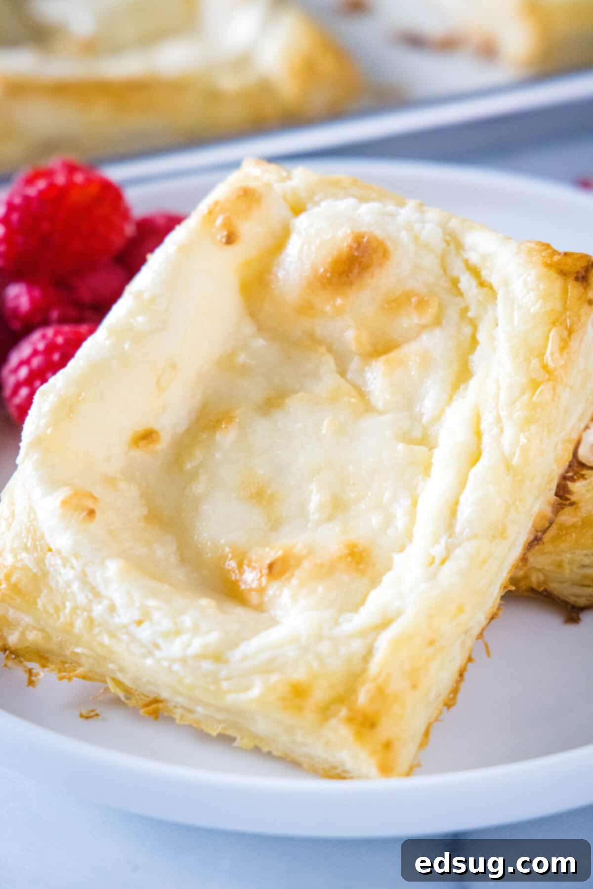 Quick and Simple Cheese Danish Freshly baked cream cheese danishes cooling on a plate, showcasing their golden crust and creamy filling