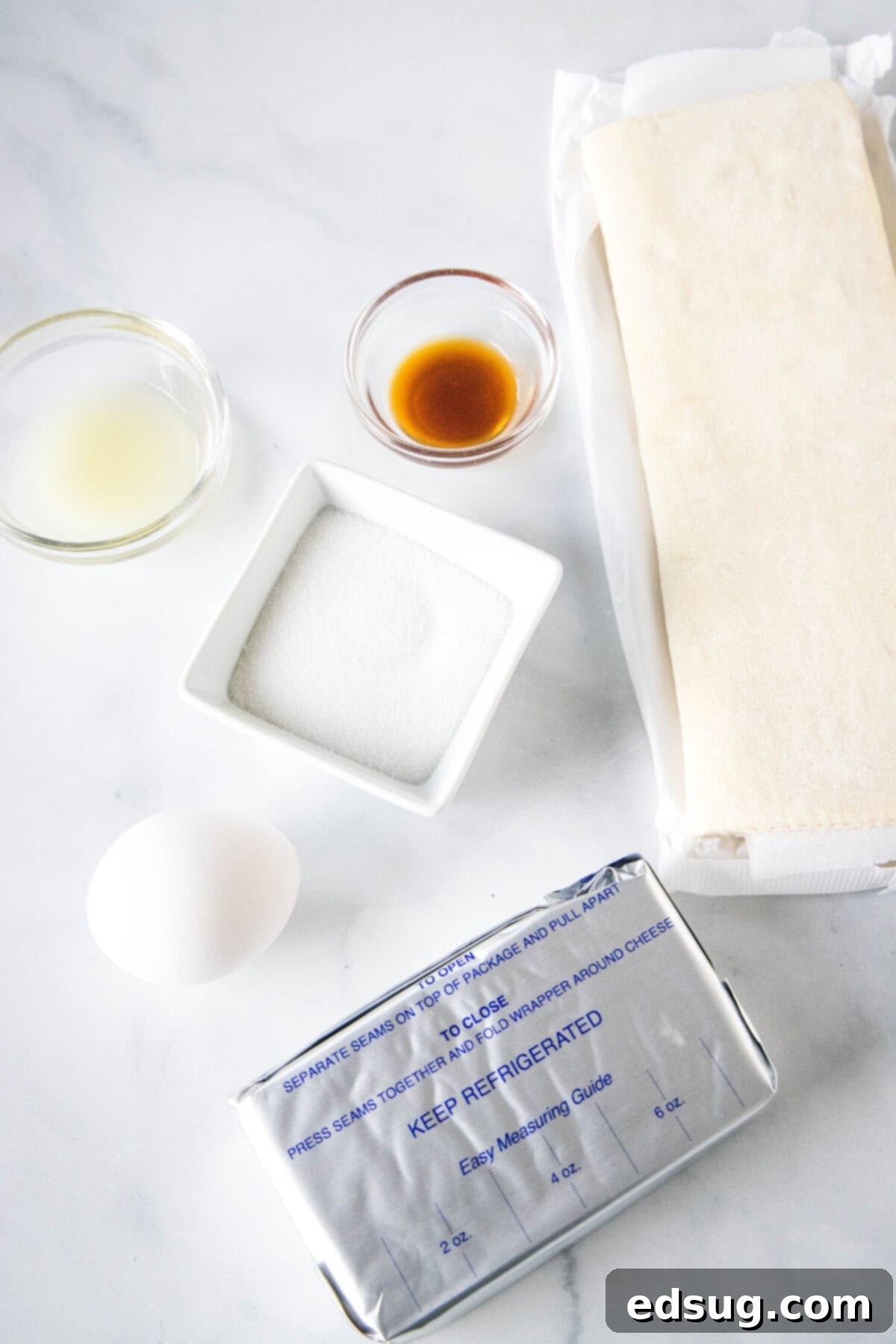 Decadent Cream Cheese Danish 2 Ingredients for cream cheese danish laid out on a counter, including puff pastry, cream cheese, and lemon