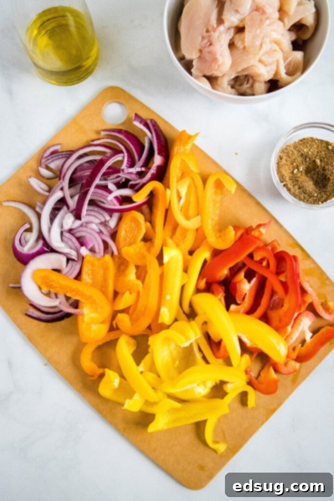 Ingredients for Instant Pot Chicken Fajitas laid out: chicken, onions, bell peppers, spices, olive oil.