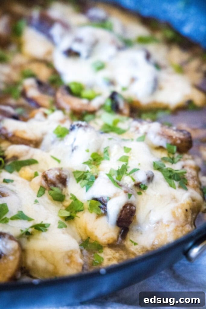 Chicken Lombardy 6 chicken with melted cheese and parsley in a skillet