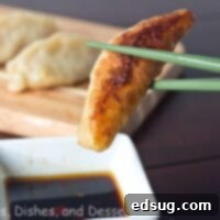 Crispy Shrimp and Pork Potstickers 3 pan fried shrimp and pork potstickers on a board