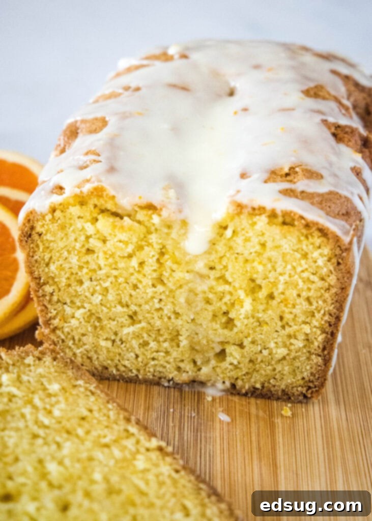 Zesty Orange Loaf 2 sliced orange bread on a cutting board, ready to be enjoyed