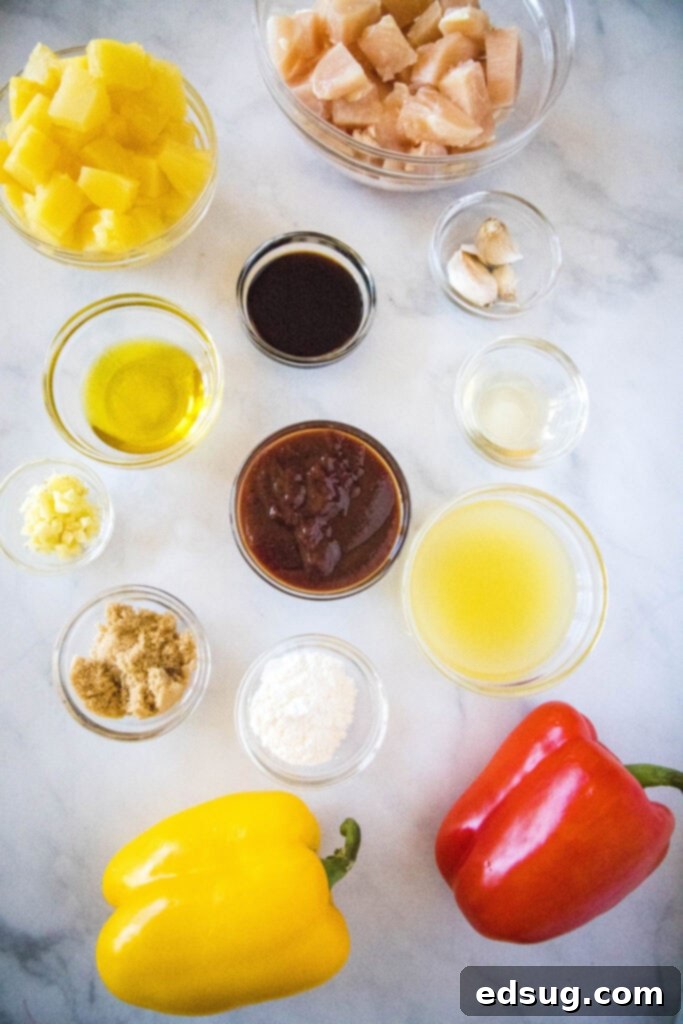Aloha Pineapple Chicken 3 All the fresh ingredients for Hawaiian Chicken laid out on a table, including chicken, bell peppers, pineapple, and various sauce components.