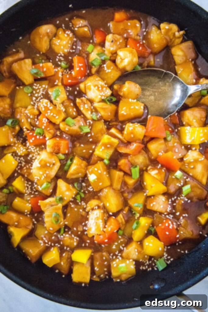 Aloha Pineapple Chicken 5 A close-up of Hawaiian Chicken stir-fry in a skillet, showing the glossy sauce coating the chicken and vegetables.