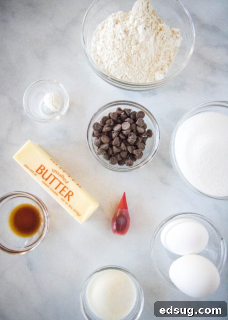 Ruby Red Indulgence 3 Red velvet brownie ingredients laid out on a white surface, including butter, chocolate chips, sugar, eggs, buttermilk, flour, baking powder, red food coloring, cream cheese, vanilla, powdered sugar, and milk.
