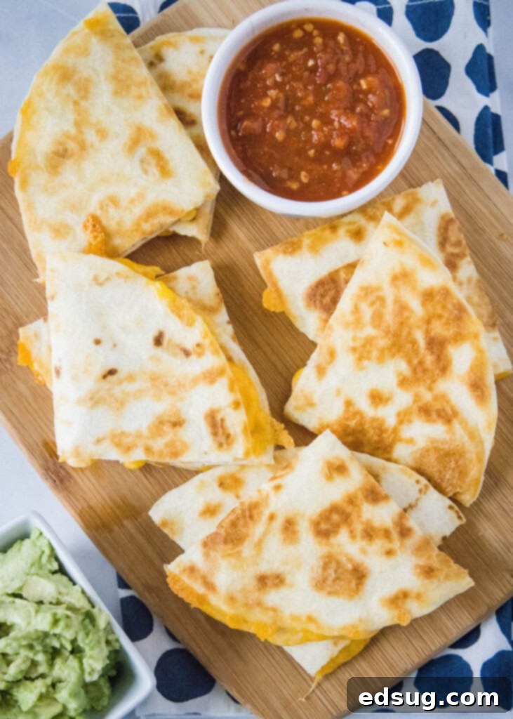 Melty Cheese Quesadilla 3 Sliced cheese quesadilla triangles served with vibrant salsa and creamy guacamole.