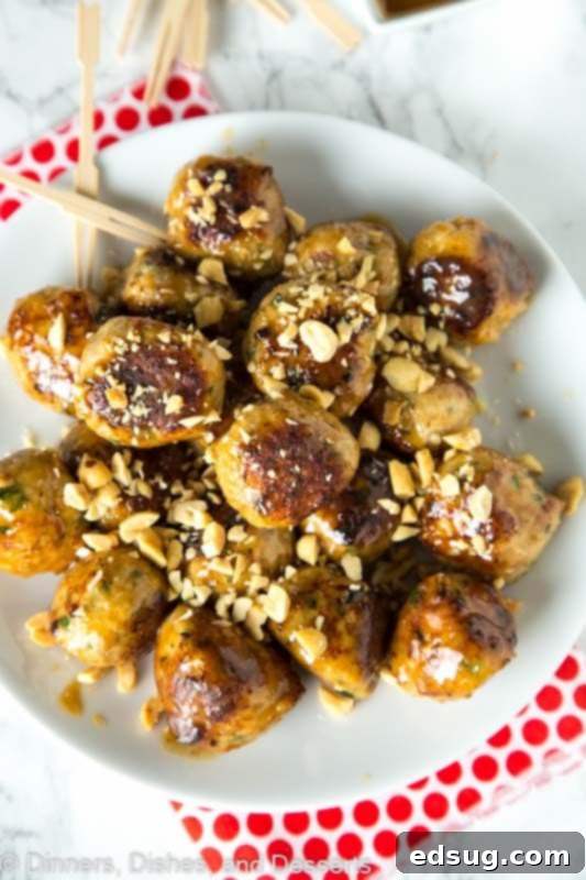 Close-up of raw chicken meatball mixture with cilantro, onion, and spices, ready to be rolled into balls.