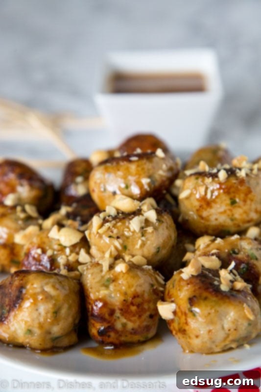 A close-up shot of pan-fried chicken meatballs, perfectly browned and ready for the peanut sauce.