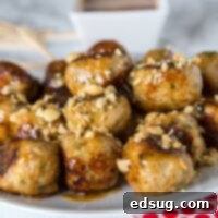 A plate of chicken meatballs with peanut sauce and chopped peanuts
