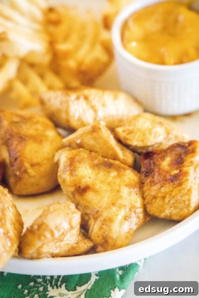 Signature Grilled Chicken Bites 2 Chick-Fil-A style grilled chicken nuggets on a plate with crispy waffle fries