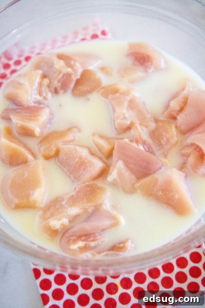 Signature Grilled Chicken Bites 3 Chicken pieces marinating in a bowl with milk and dill pickle juice