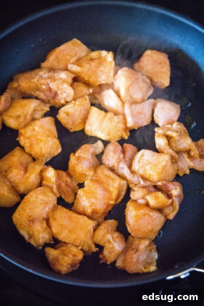 Signature Grilled Chicken Bites 5 Chicken nuggets cooking in a hot skillet on the stovetop