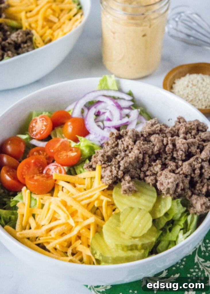 Big Mac Style Salad 3 Big Mac Salad served in a pristine white bowl, with a jar of the special dressing positioned artfully behind it.