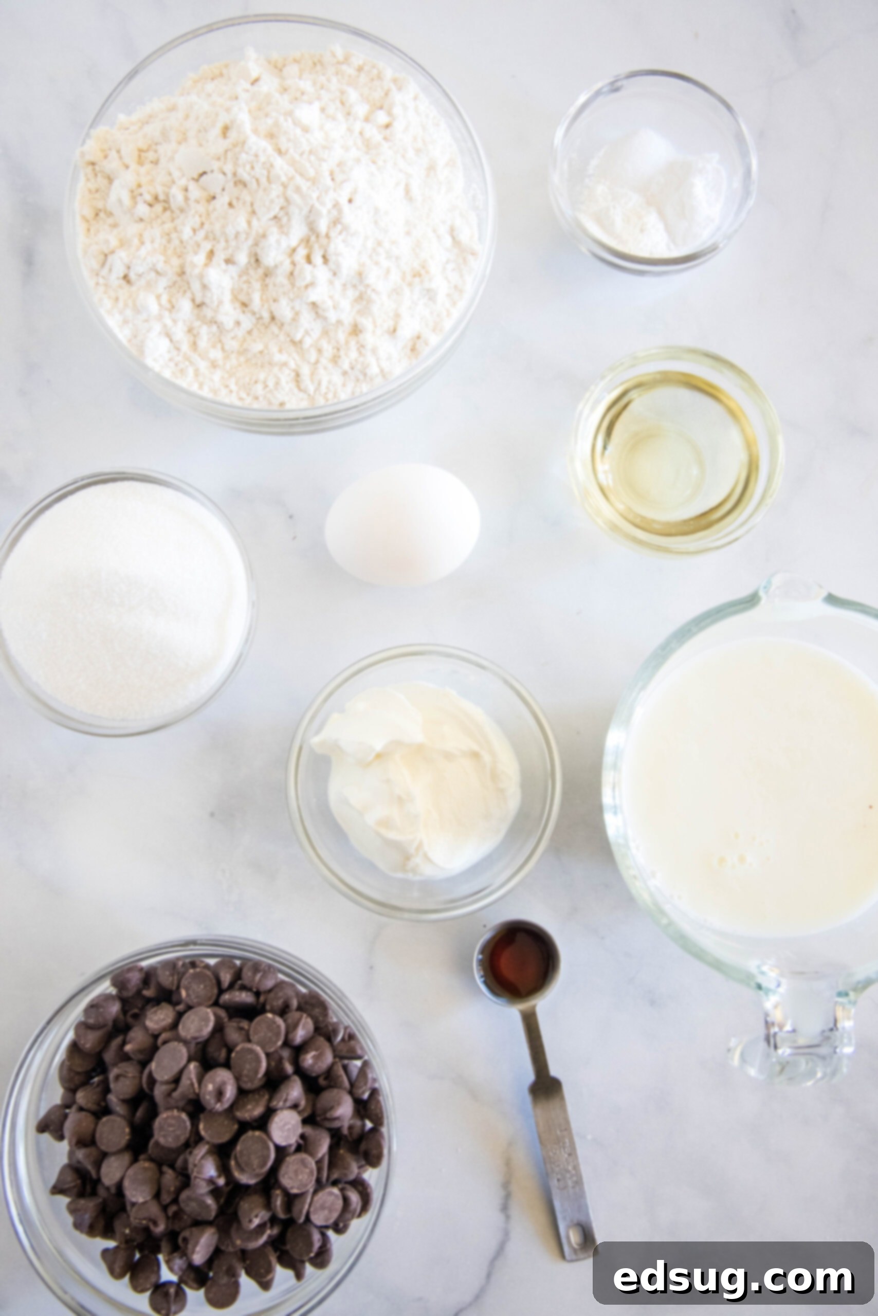 A collection of ingredients for buttermilk chocolate chip muffins laid out on a table.
