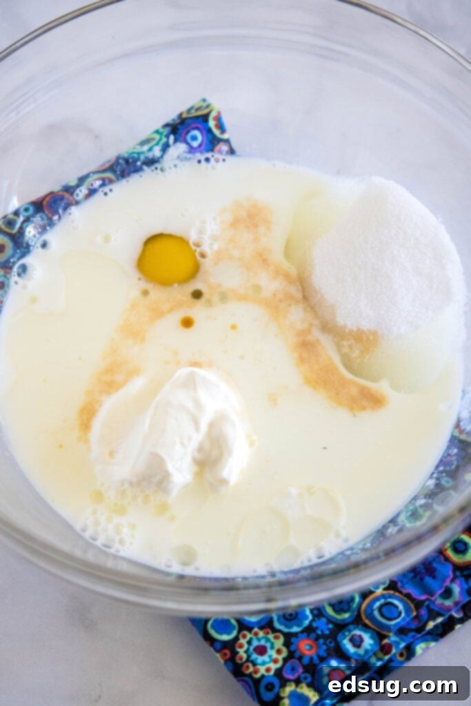Buttermilk muffin ingredients combined in a glass bowl, illustrating the initial wet mixture stage.