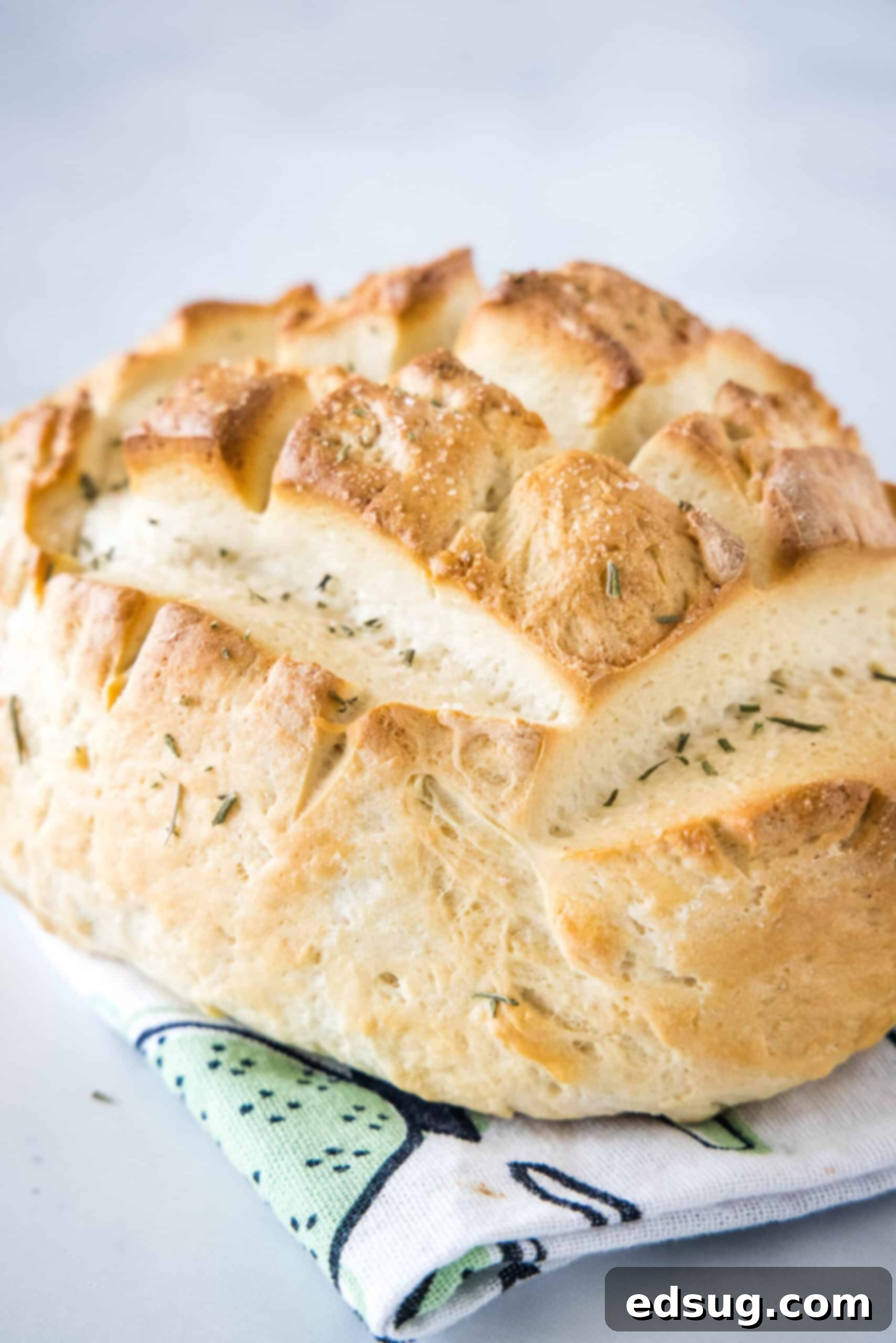 Baked Amish bread on top of a dishcloth, showcasing its golden-brown crust and inviting texture.