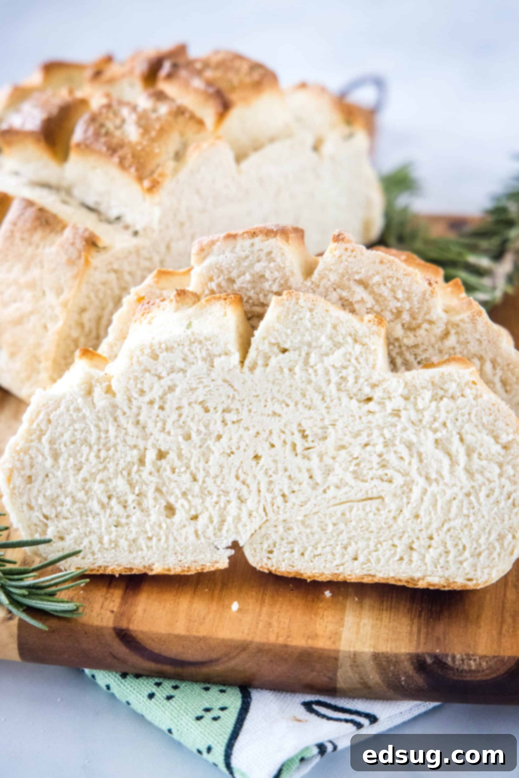 Slices of freshly baked Amish bread on a wooden cutting board with the rest of the loaf in the background, ready to be enjoyed.