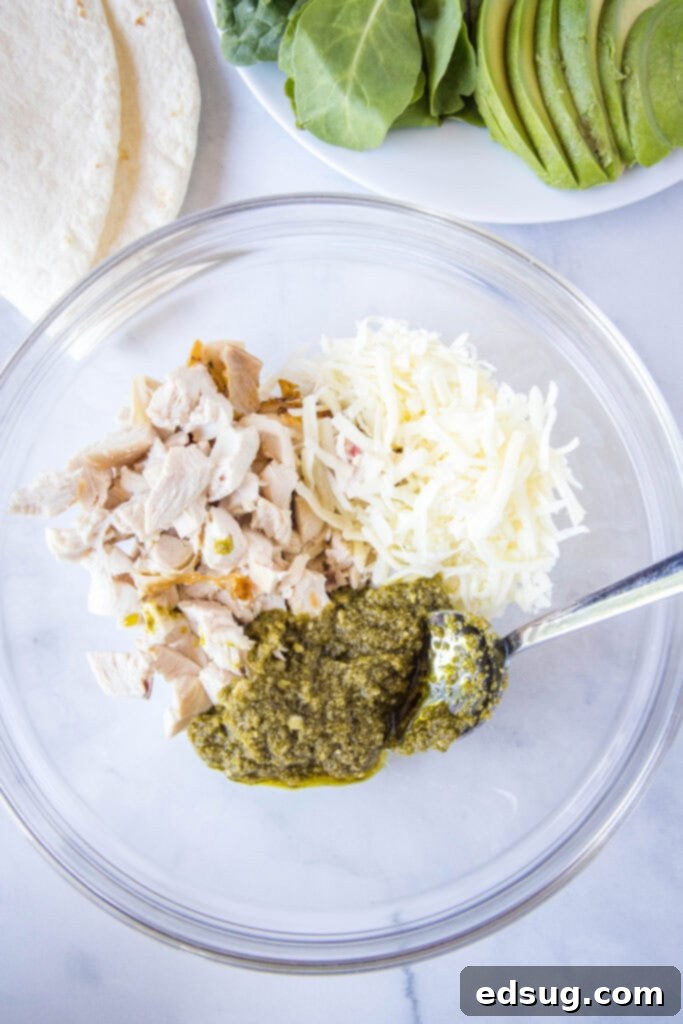 Pesto Chicken Delights 3 mixing chicken, pesto and cheese in a bowl