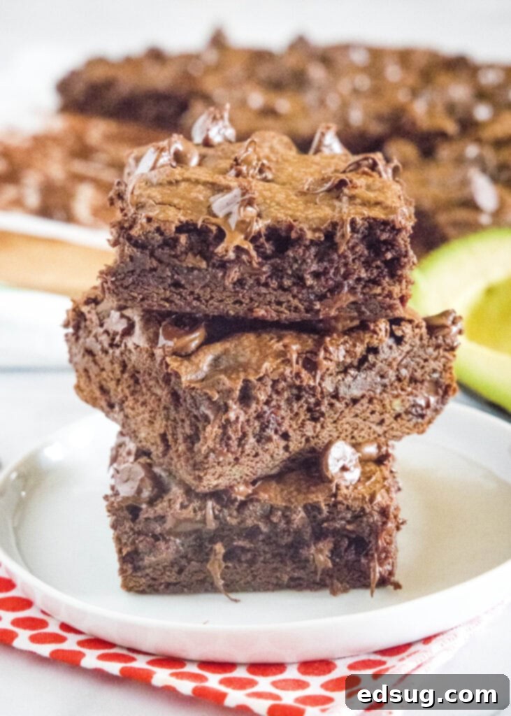 Decadent Avocado Brownies 2 stacked avocado brownies on a white plate
