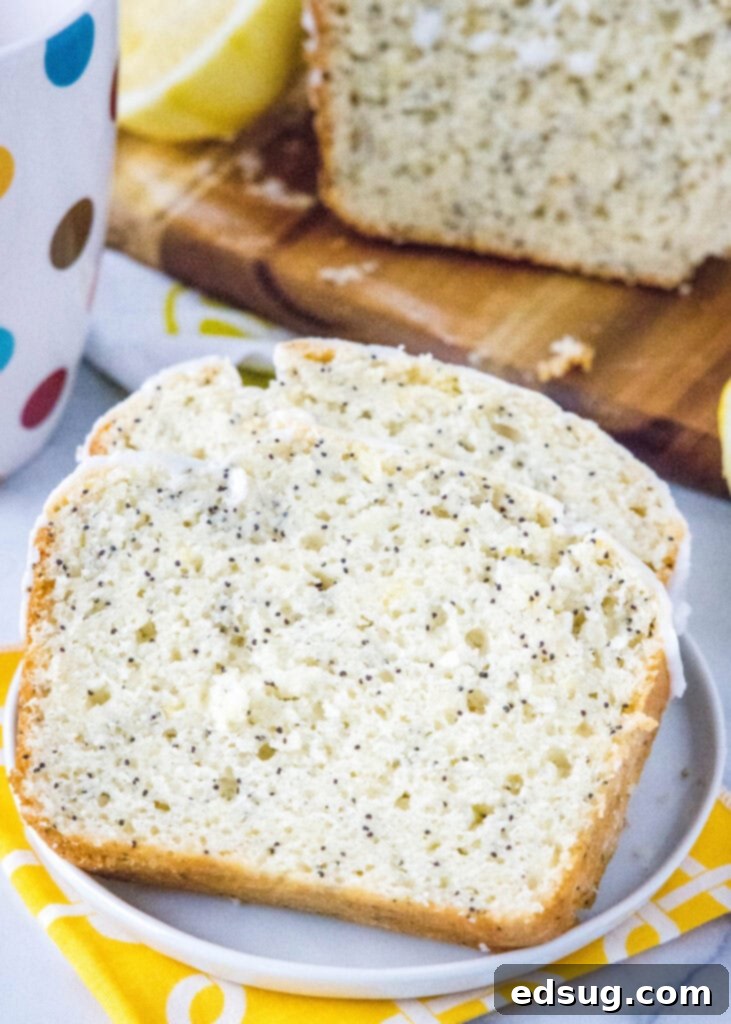 Several slices of lemon poppy seed bread arranged on a white plate, showing the soft interior.