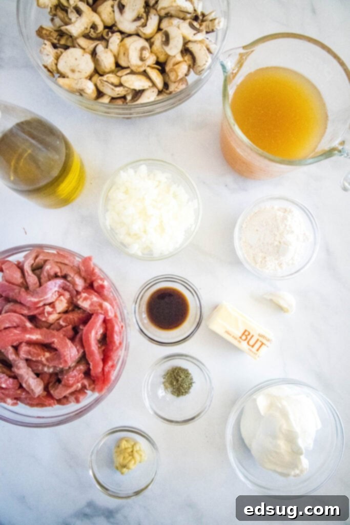 Classic Beef Stroganoff 3 A selection of fresh ingredients for making beef stroganoff laid out on a wooden board