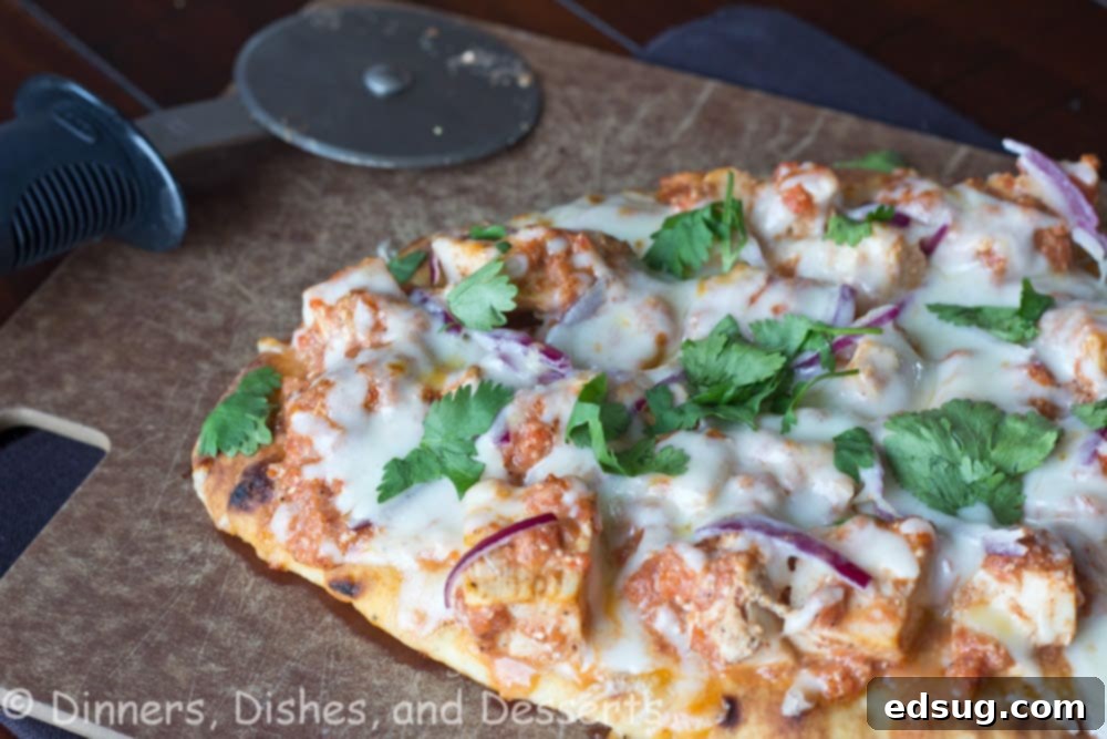 Chicken Tikka Pizza Chicken tikka pizza sliced into generous portions and ready to serve, showcasing its vibrant colors and fresh toppings.