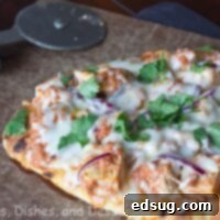 Ultimate Chicken Tikka Pizza 1 chicken tikka pizza on a board with fresh cilantro for garnish