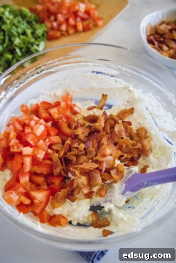 adding tomatoes and bacon to a mixing bowl