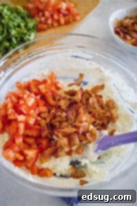 adding tomatoes and bacon to a mixing bowl