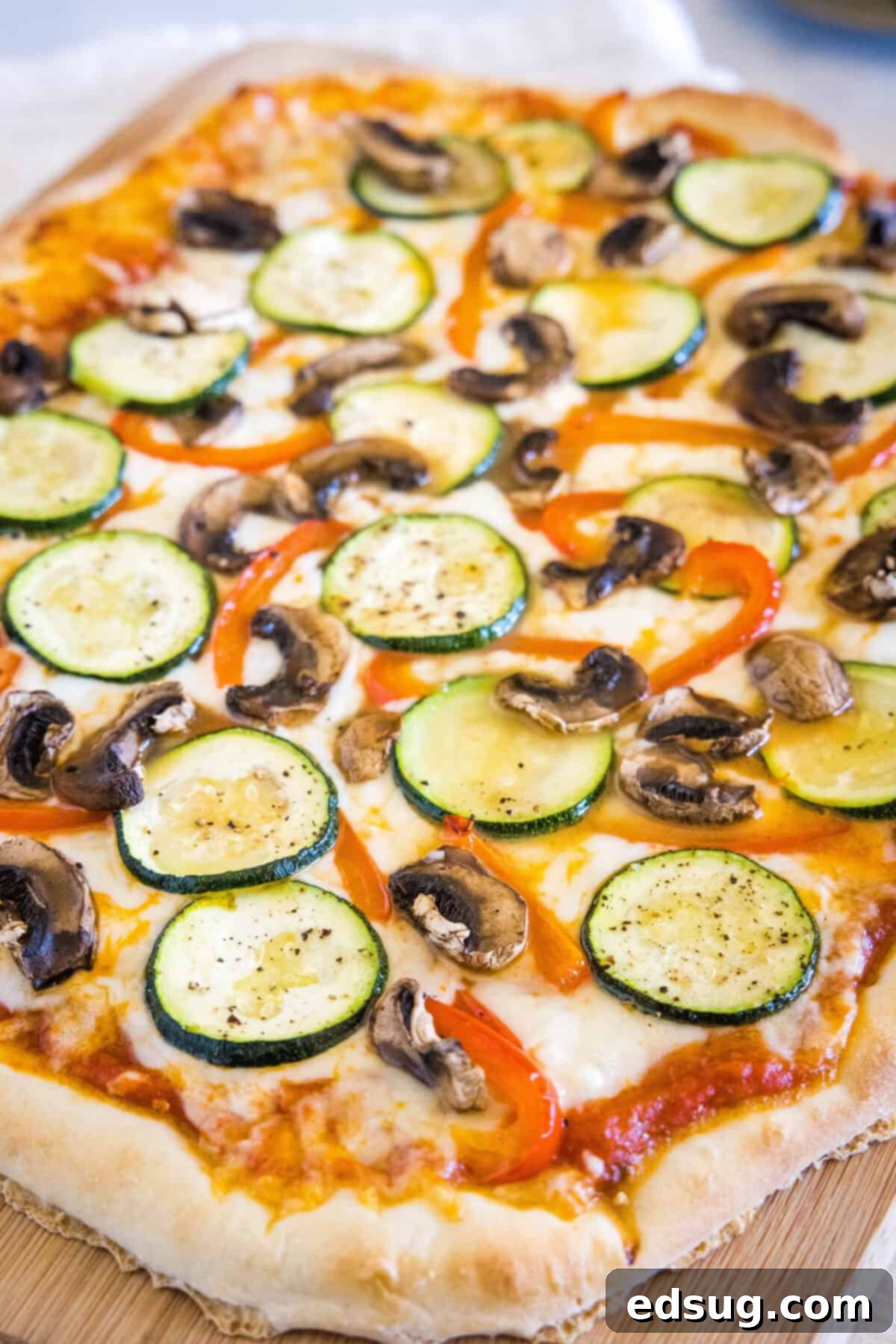Roasted Veggie Pizza | Dinners, Dishes, and Desserts A whole roasted vegetable pizza with visible zucchini, mushrooms, and bell peppers, ready to be sliced.