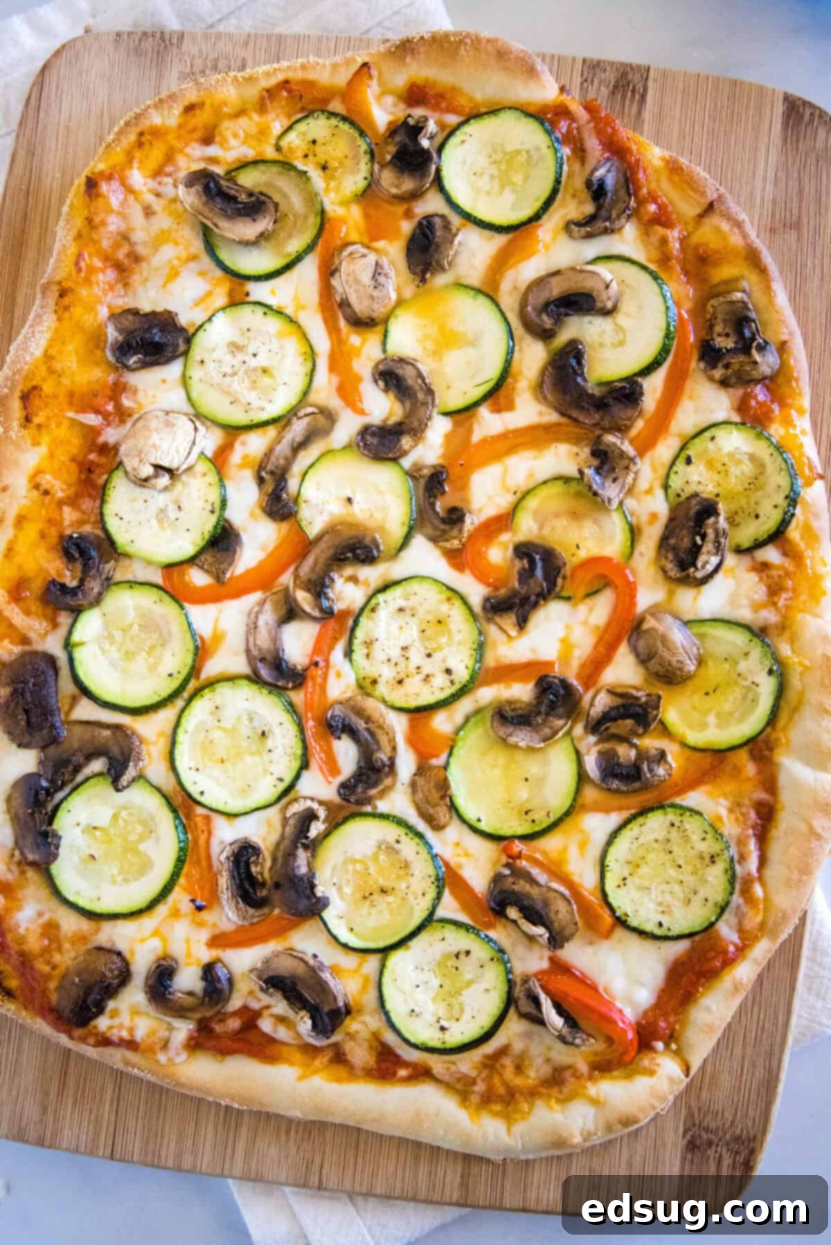 Gourmet Roasted Vegetable Pizza 4 A freshly baked roasted vegetable pizza on a cutting board, garnished with fresh herbs, ready to be served.