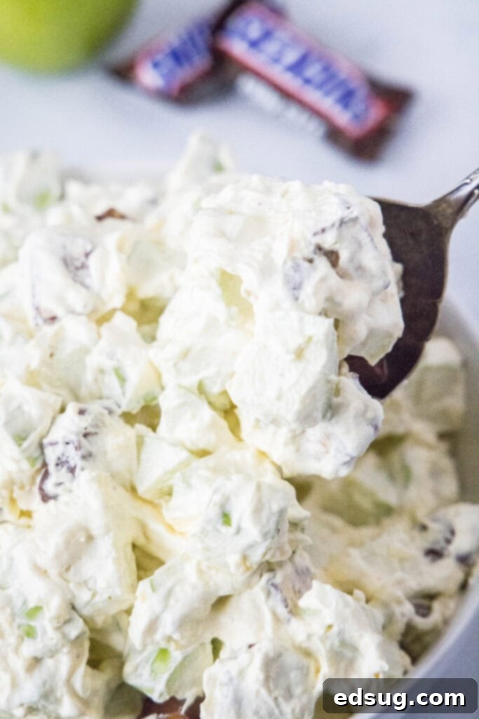 spooning candy salad out of serving bowl